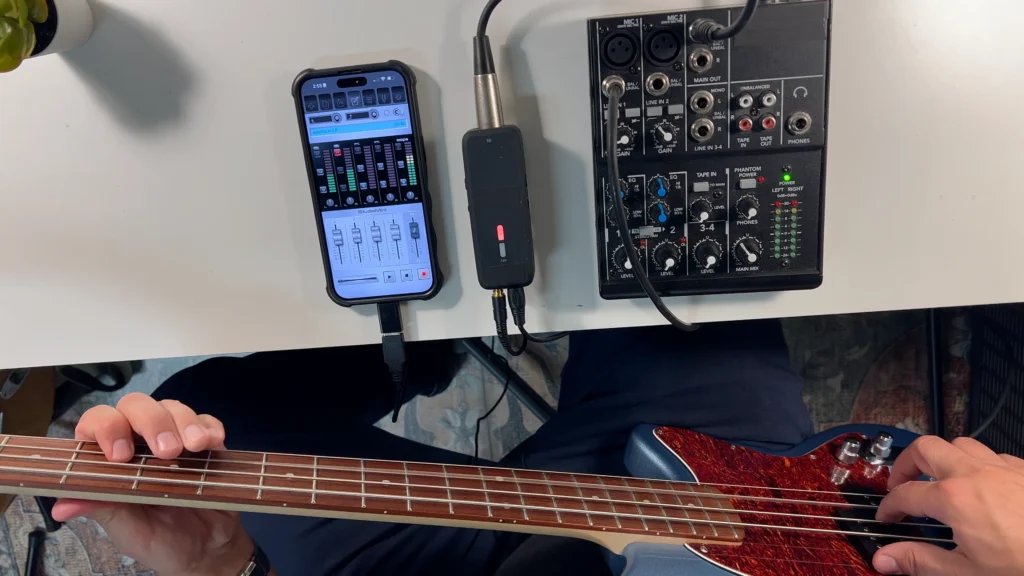 Screenshot of StudioMini on iPhone showing the bass guitar recording setup going direct with a DI chain from a mixer to a portable USB audio interface.