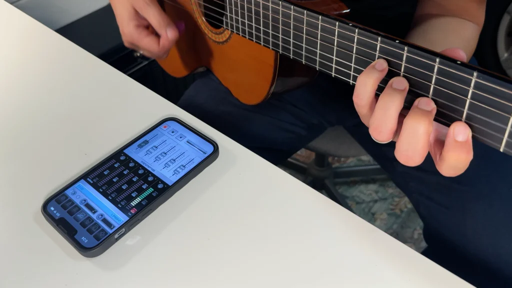 Screenshot of StudioMini on iPhone showing the acoustic guitar recording setup with Track 1 armed for recording.