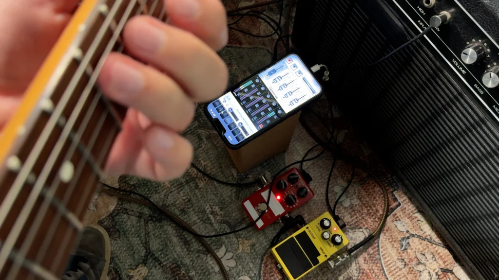 Screenshot of StudioMini on iPhone showing the electric guitar recording setup with amp and iPhone mic